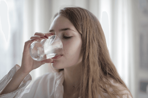 Lady drinking water with collagen supplement