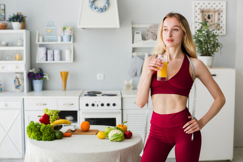 A slim lady holding a glass of juice